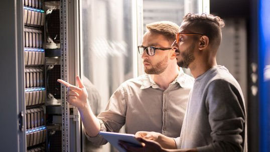 2 Männer reden gemeinsam im Serverraum 2 Männer reden gemeinsam im Serverraum
